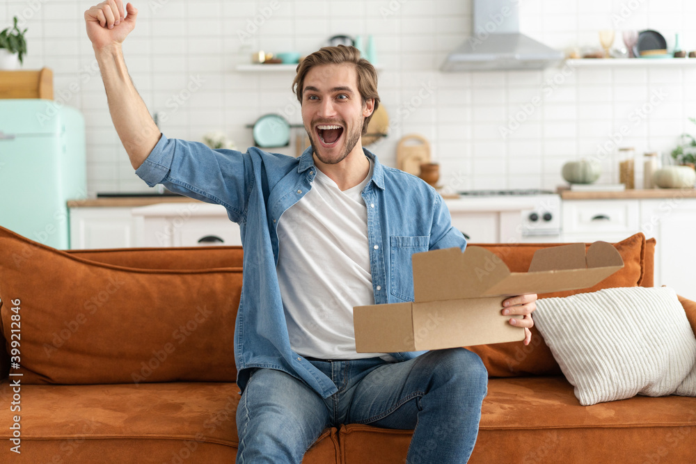 Fototapeta premium Happy man customer unpacking cardboard box receive open post mail delivery package