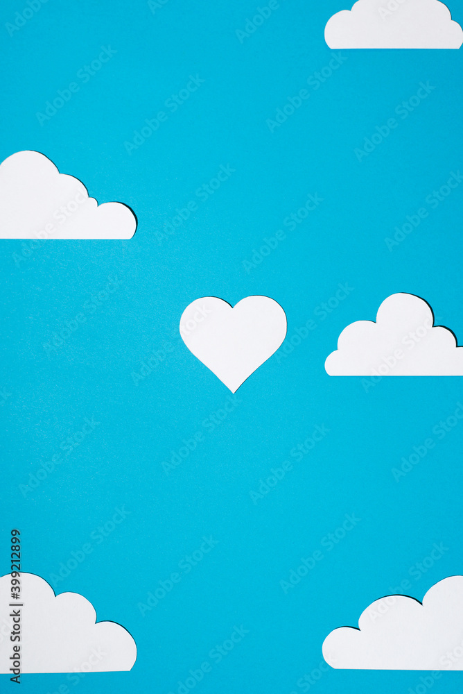 Heart and clouds cut from paper on a blue background. Flat lay, top view. Concept of love, celebration, valentine's day. Heart and clouds cut from paper on a blue background. Flat lay, top view. Concept of love, celebration, valentine's day.