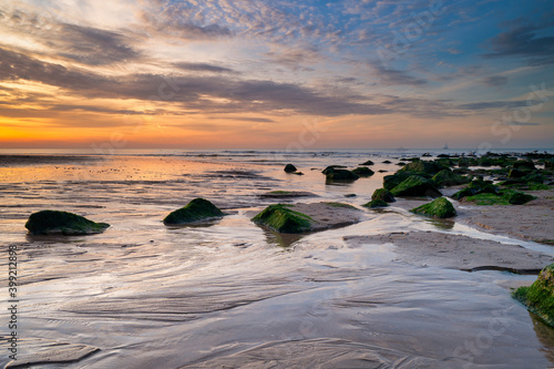 Beautiful sunset on the beach. Blurry seagulls in the background. An impressive sky