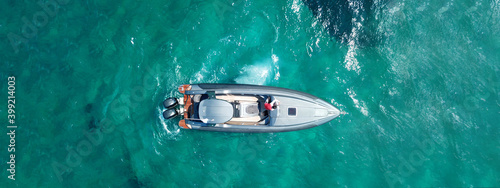 Aerial drone ultra wide top view panoramic photo of luxury inflatable rib speed boat anchored in exotic emerald bay with crystal clear sea