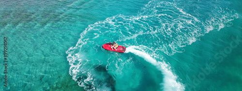 Aerial drone ultra wide photo of jet ski watercraft with couple cruising in high speed in Caribbean tropical exotic turquoise crystal clear sea © aerial-drone