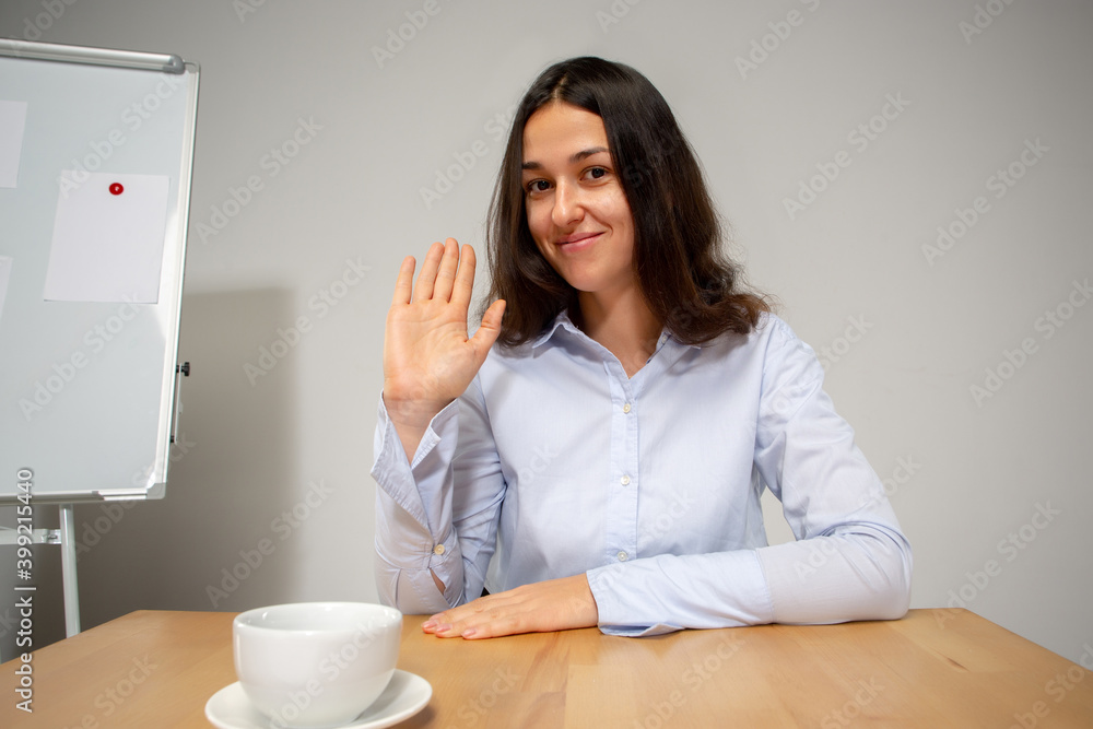 Greeting. Young woman working in videoconference with colleagues, co-workers at office. Online business, education during coronavirus insulation and quarantine. Work, finance, modern tech concept. Greeting. Young woman working in videoconference with colleagues, co-workers at office. Online business, education during coronavirus insulation and quarantine. Work, finance, modern tech concept.