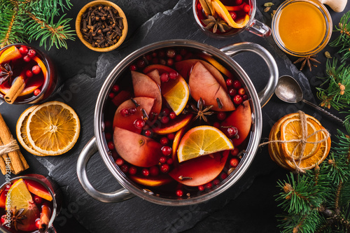 Foto Top-down view of cooking pot of hot wine with aromatic spices on a black textured background