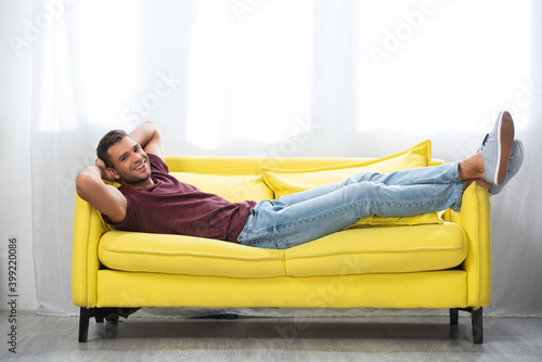  man looking at camera while lying with crossed legs on couch