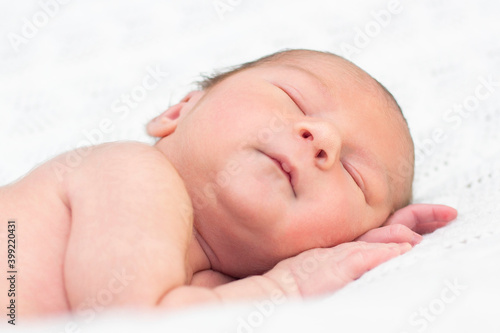 newborn baby sleeps and smiles.