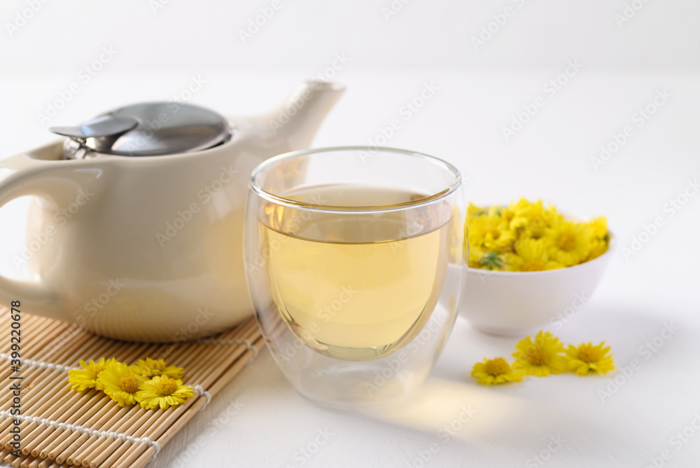 Organic Chrysanthemum flower tea in a cup and teapot on white background, Healthy Herbal drink Organic Chrysanthemum flower tea in a cup and teapot on white background, Healthy Herbal drink