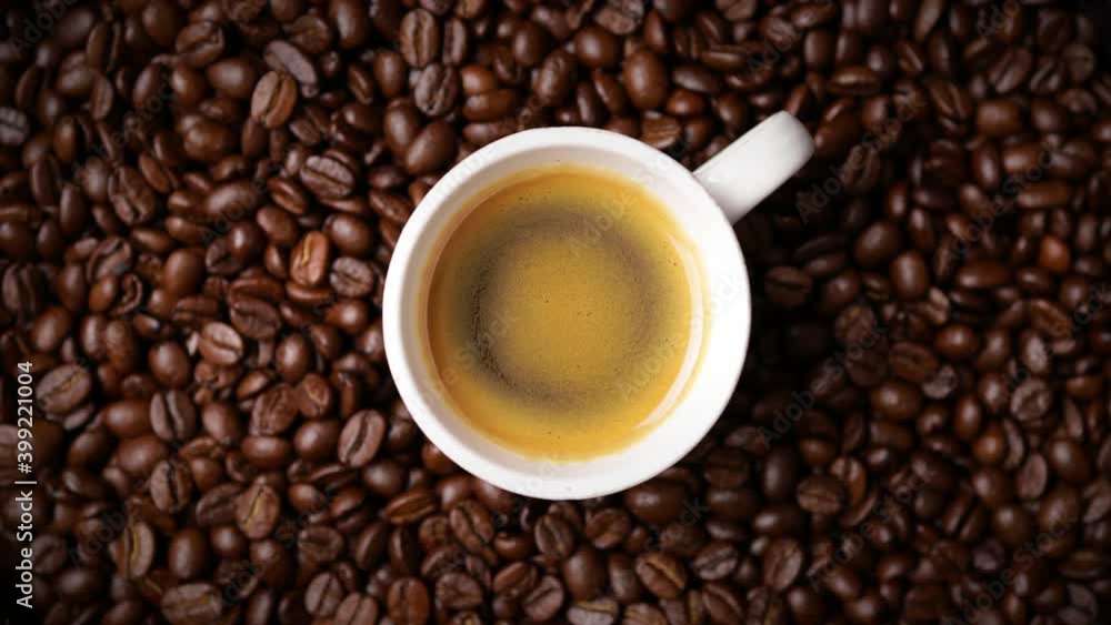 cup of coffee with freshly roasted coffee beans background (seamless looping) cup of coffee with freshly roasted coffee beans background (seamless looping)