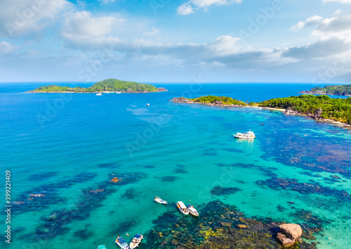 Aerial view of beautiful landscape, tourism boats, and people swimming on the sea and beach on May Rut island (a tranquil island with beautiful beach) in Phu Quoc, Kien Giang, Vietnam.