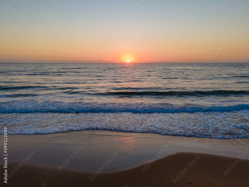 Hazy sunrise seascape with low swell Hazy sunrise seascape with low swell