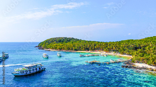 Aerial view of beautiful landscape, tourism boats, and people swimming on the sea and beach on May Rut island (a tranquil island with beautiful beach) in Phu Quoc, Kien Giang, Vietnam. photo