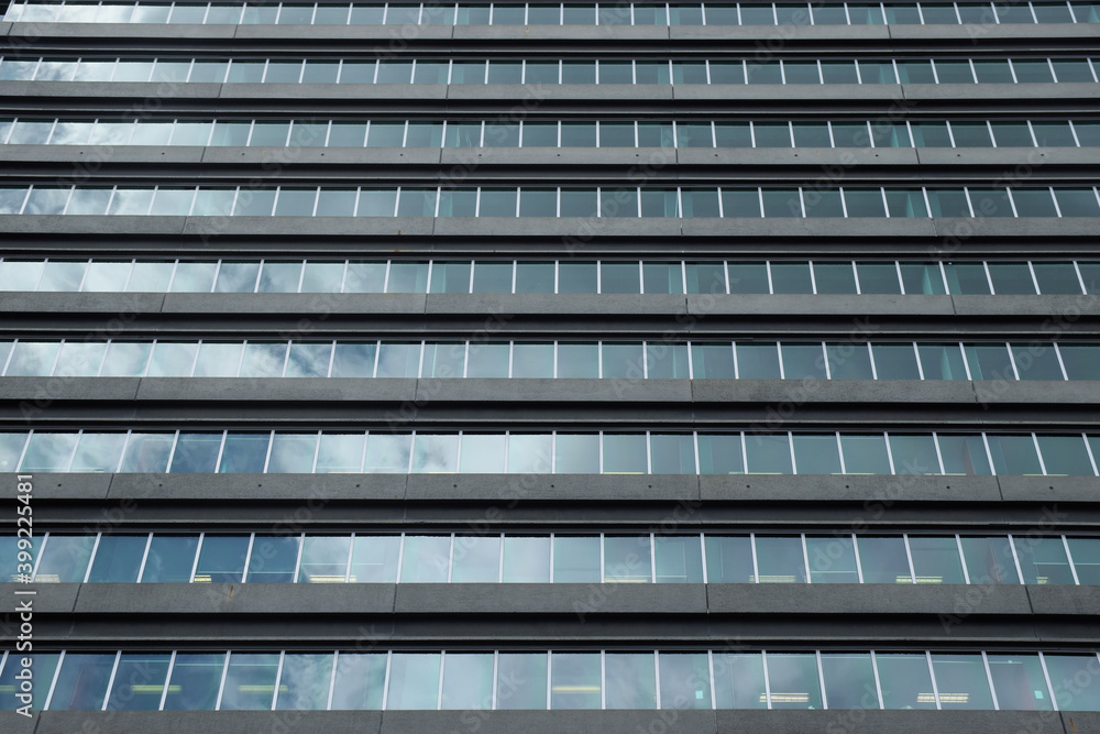Detail of an office building window with reflection of clouds and sky Detail of an office building window with reflection of clouds and sky