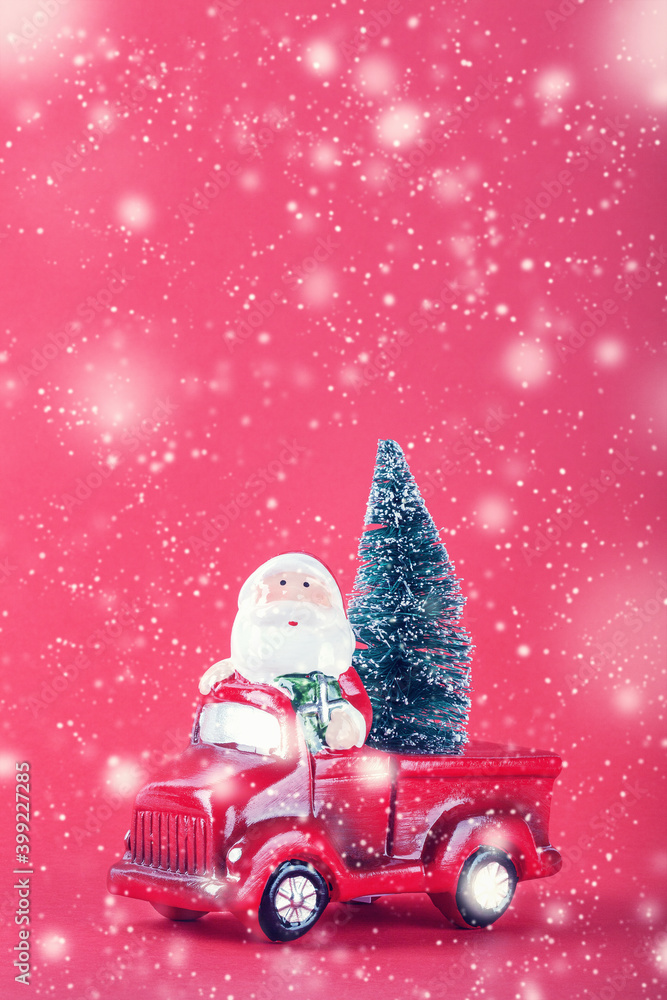 Santa Claus on red car toy with Christmas tree on red background and snow. Santa Claus on red car toy with Christmas tree on red background and snow.