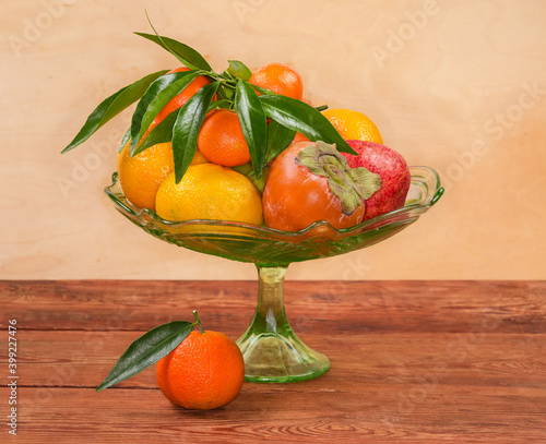 Different fruits in vintage glass fruit vase on rustic table