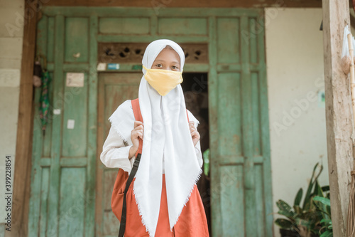 indonesian asian primary student wearing a masks before going to school photo