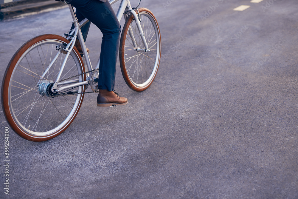 Faceless man riding bicycle on asphalt road Faceless man riding bicycle on asphalt road