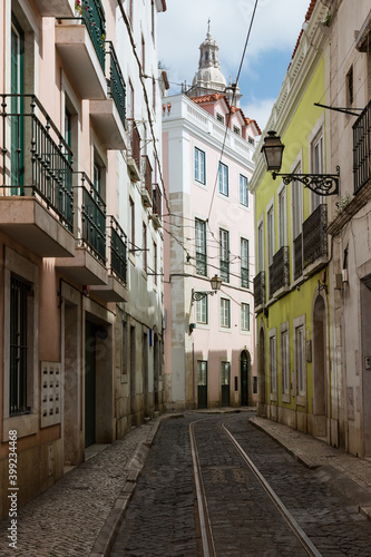 Empty narrow cobblestone street or alley with tramway rails, Lisbon, Portugal