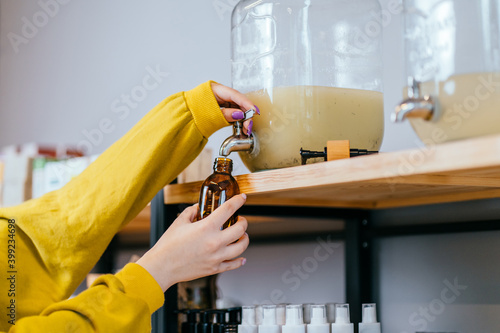 Фотография Unrecognizable woman pouring shampoo from a dispenser