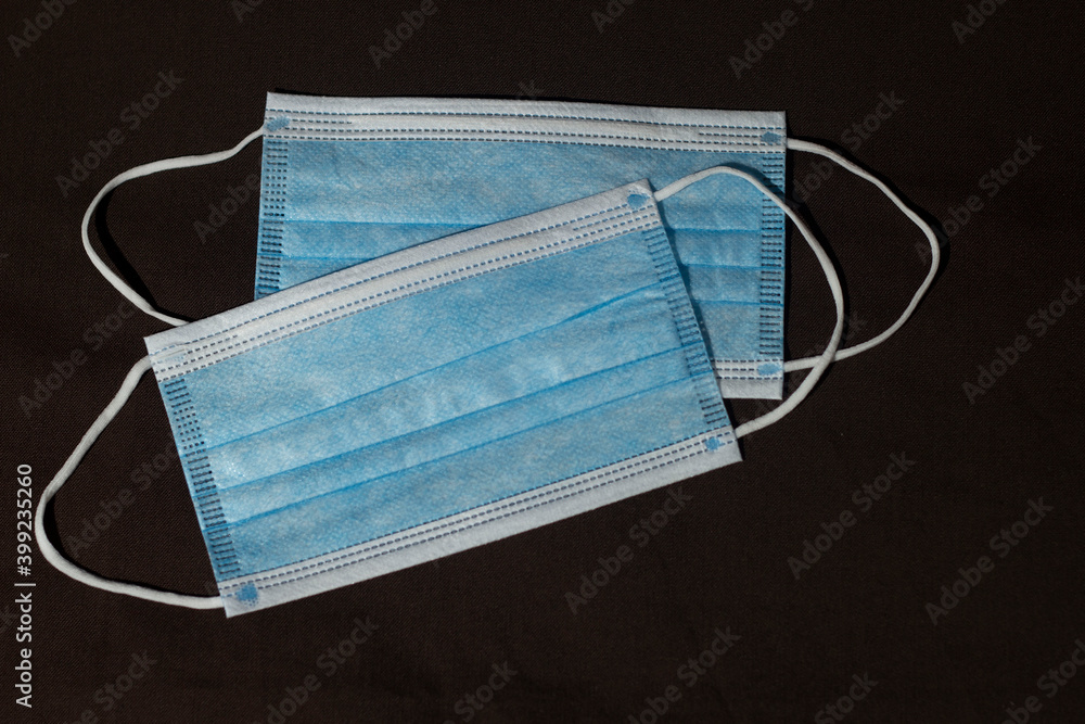Medical mask lie on a dark background, top view. Medical mask lie on a dark background, top view.