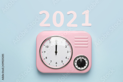 Clock with figure 2021 on color background