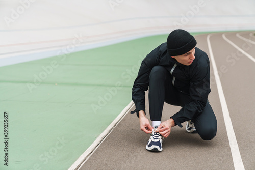 Young man runner tying shoelaces