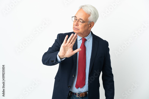 Middle age Brazilian business man isolated on white background making stop gesture and disappointed © luismolinero