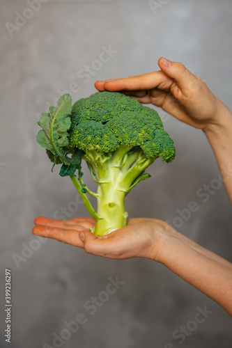 Raw broccoli in hand. Vegeterian food or diet concept.