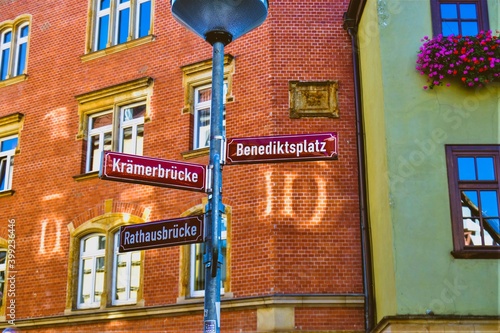 22.10.2011. Erfurt. Germany. Street signs. It shows that famous bridge and town hall street. It stays in front of ancient house made of red bricks and yellow house,where beautiful flowers in window. photo