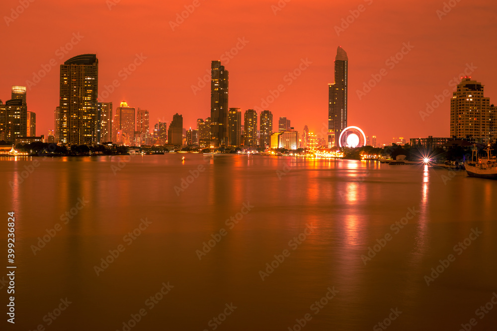 Blurred abstract background of high-rise buildings built by the river, lit at night, the distribution of residences of today's capital so Blurred abstract background of high-rise buildings built by the river, lit at night, the distribution of residences of today's capital so