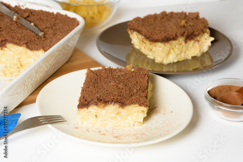 Hanukkah holiday, traditional sweet Kugel pie with noodles and custard, shortbread cocoa crumbs on top. on a light background in a baking dish. pie slices on a plate