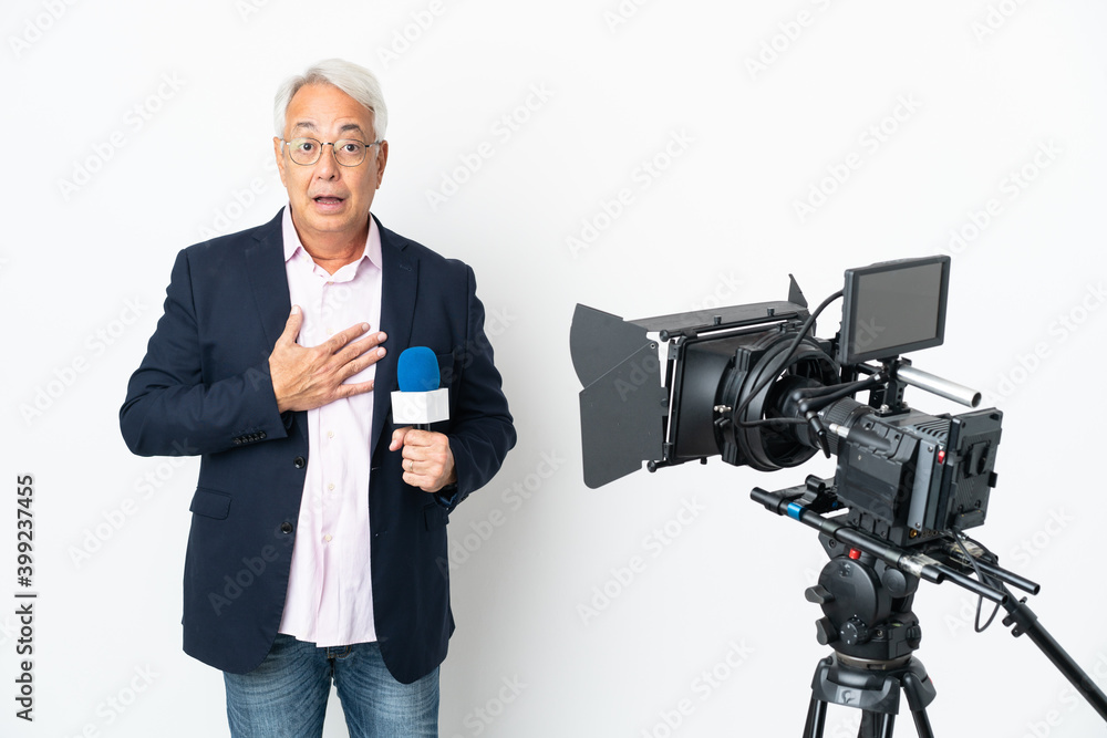 Reporter Middle age Brazilian man holding a microphone and reporting news isolated on white background surprised and shocked while looking right