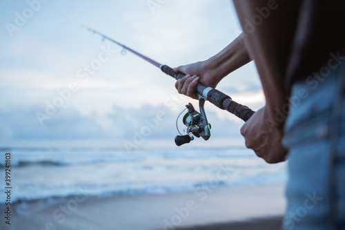 Portrait of a young fisherman fishing alone by the beach
