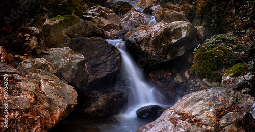 Small stream and small waterfall in autumn forest. Photographed with long exposure