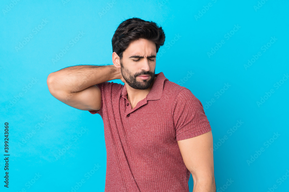 Young handsome man with beard over isolated blue background with neckache Young handsome man with beard over isolated blue background with neckache