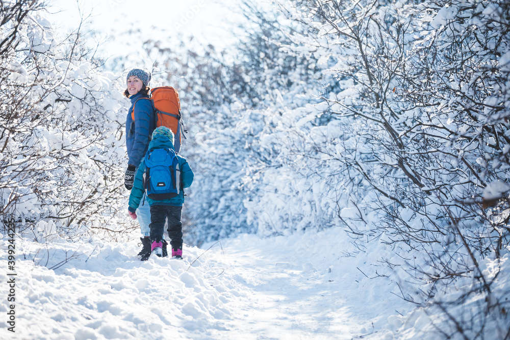 Woman with a child on a winter hike in the mountains.