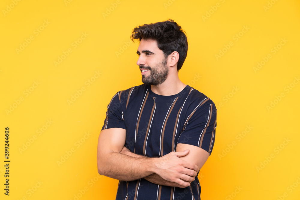 Young handsome man with beard over isolated yellow background looking to the side Young handsome man with beard over isolated yellow background looking to the side