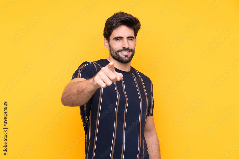 Young handsome man with beard over isolated yellow background points finger at you Young handsome man with beard over isolated yellow background points finger at you