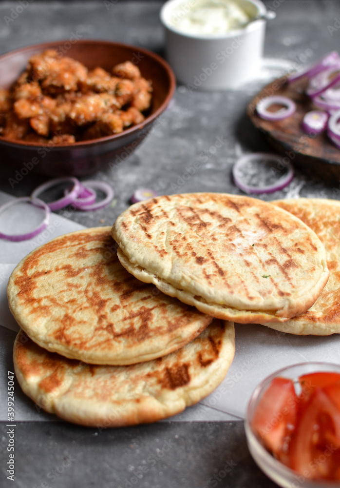 Ingredients for making pita with chicken. Healthy fast food. Dark background. Tomatoes, red onion, chicken nuggets. Ingredients for making pita with chicken. Healthy fast food. Dark background. Tomatoes, red onion, chicken nuggets.