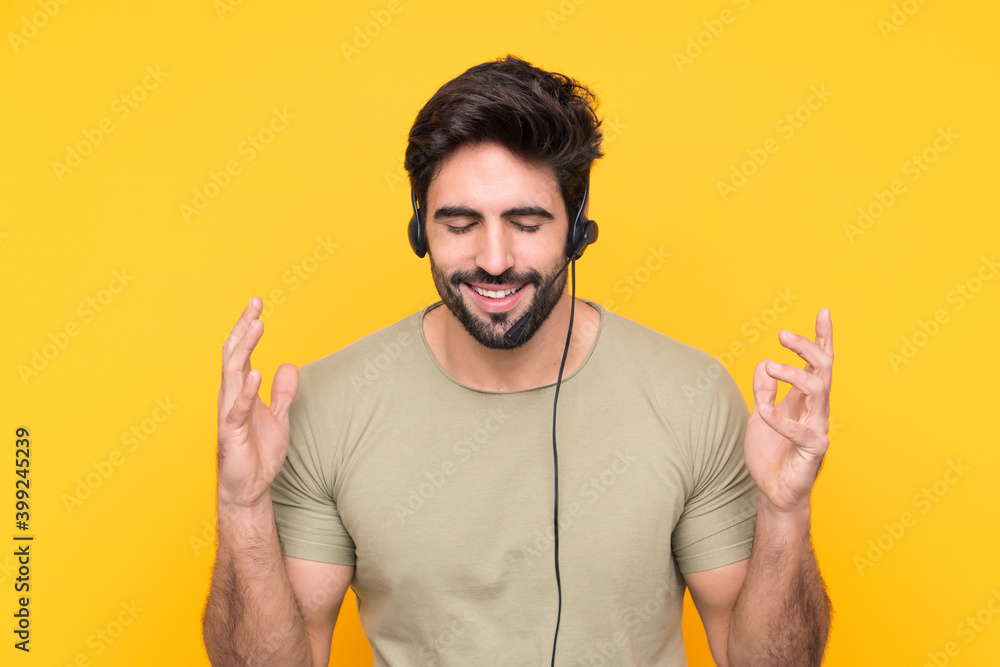 Telemarketer man working with a headset over isolated yellow background laughing Telemarketer man working with a headset over isolated yellow background laughing