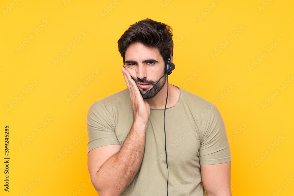 Telemarketer man working with a headset over isolated yellow background unhappy and frustrated Telemarketer man working with a headset over isolated yellow background unhappy and frustrated