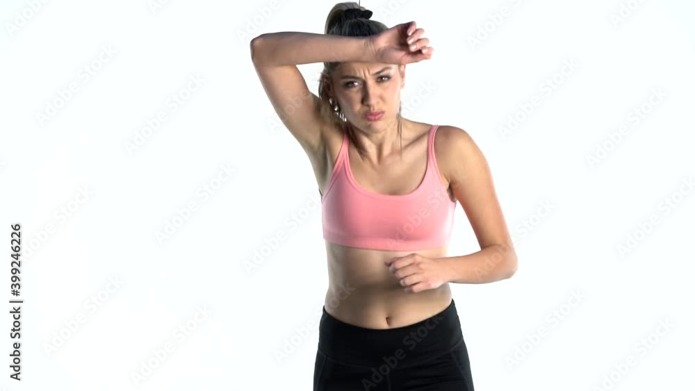 slow motion of a young tired woman running and wiping sweat from her forehead. front view on white background slow motion of a young tired woman running and wiping sweat from her forehead. front view on white background