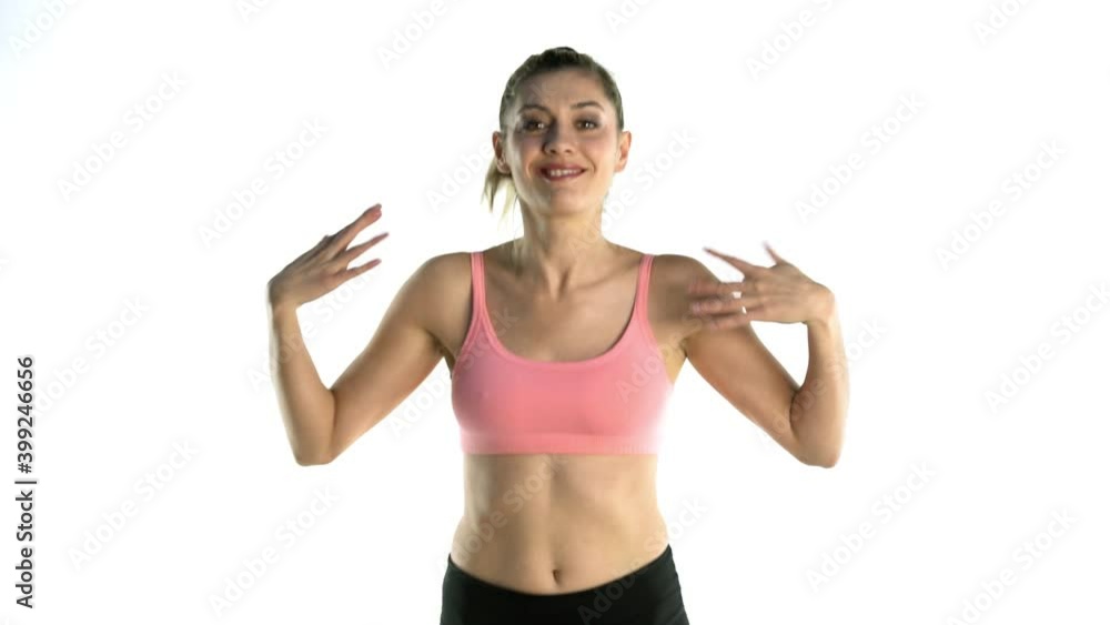 Slow motion of sporty happy and smiling woman jumping and doing arm warm-up exercises on white background. front view Slow motion of sporty happy and smiling woman jumping and doing arm warm-up exercises on white background. front view