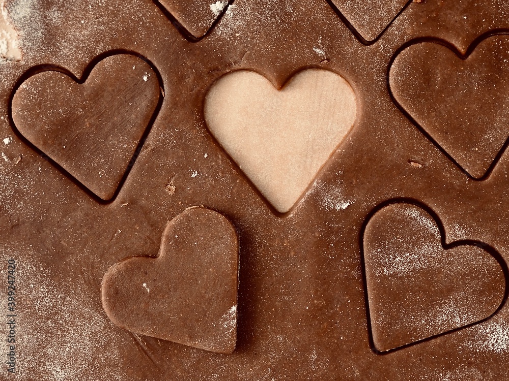 Valentine's day. Cutting out hearts from rolled dough for making Christmas cookies.