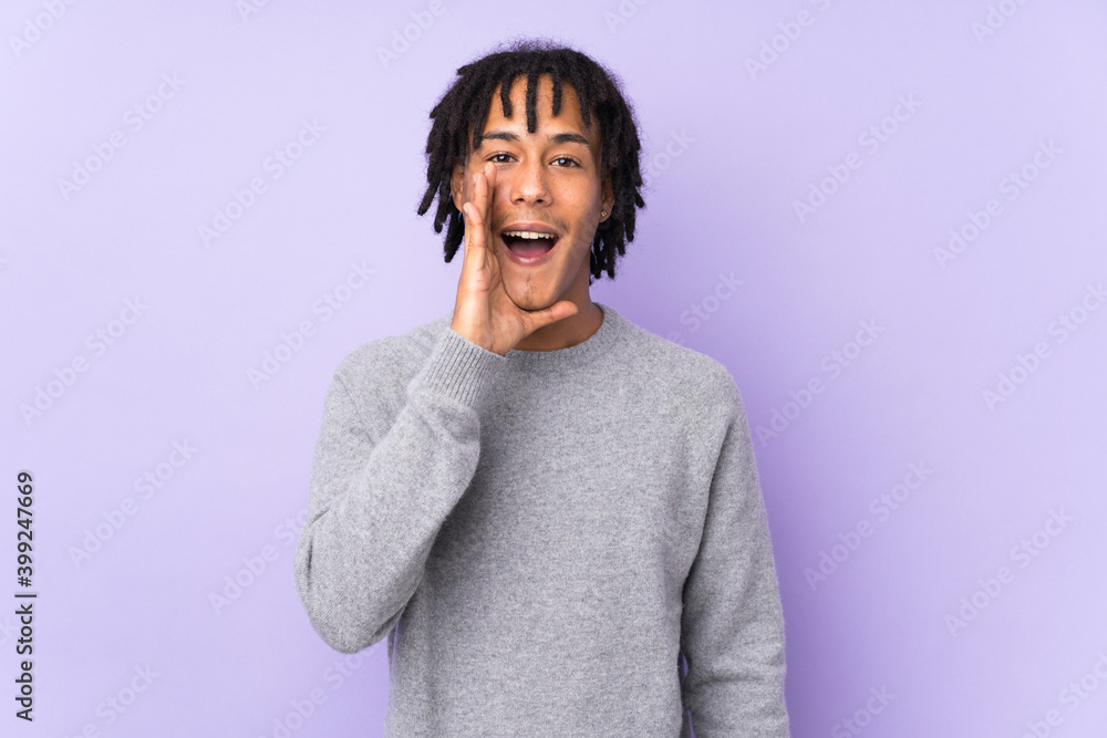Young african american man isolated on purple background shouting with mouth wide open Young african american man isolated on purple background shouting with mouth wide open