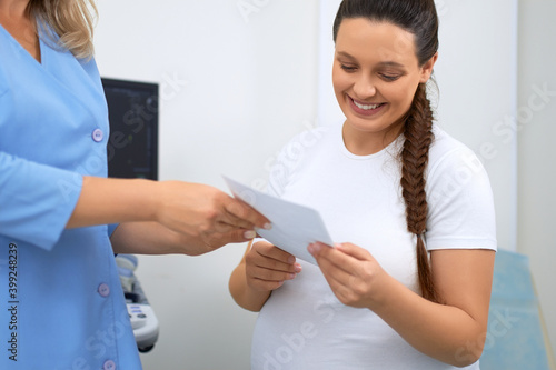 Smiling pregnant woman having diagnostic at clinic