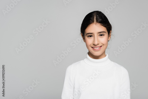 Positive hispanic child looking at camera isolated on grey