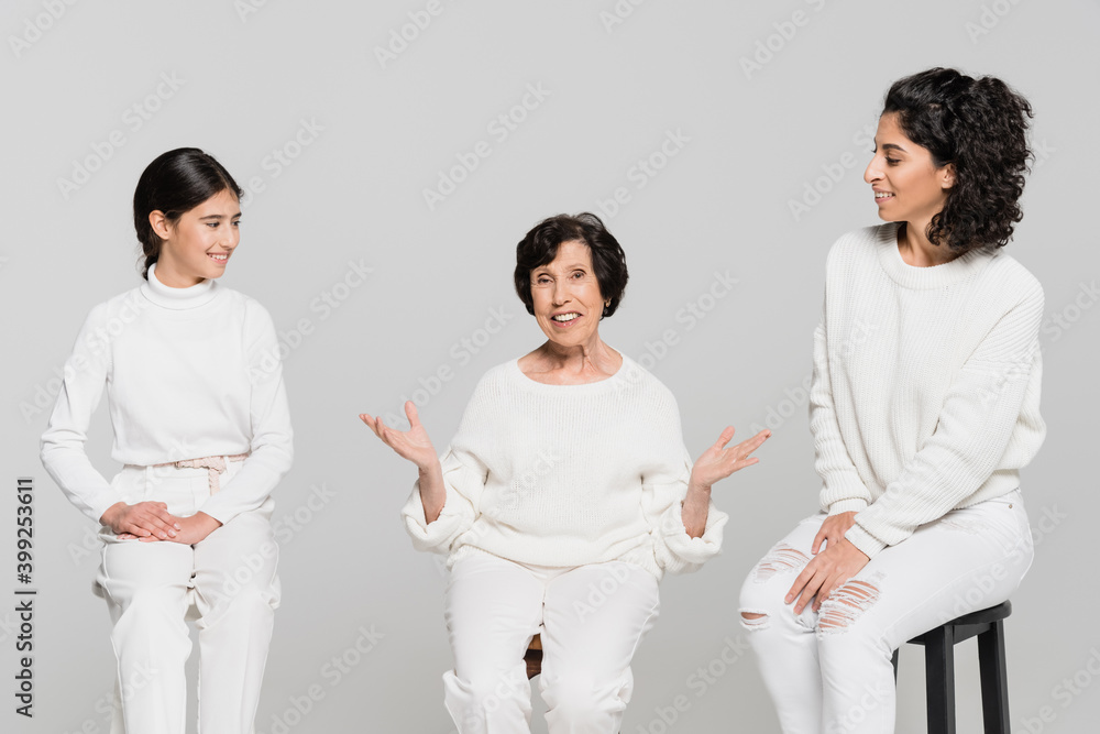 Elderly hispanic woman pointing with hands at smiling daughter and daughter isolated on grey, three generations of women Elderly hispanic woman pointing with hands at smiling daughter and daughter isolated on grey, three generations of women