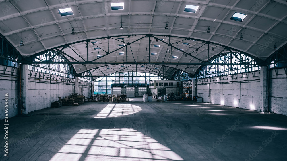 Obraz premium Huge industrial warehouse. Modern interior. Unique architecture. Hemispherical reinforced concrete load bearing roof. Stack wooden pallets.
