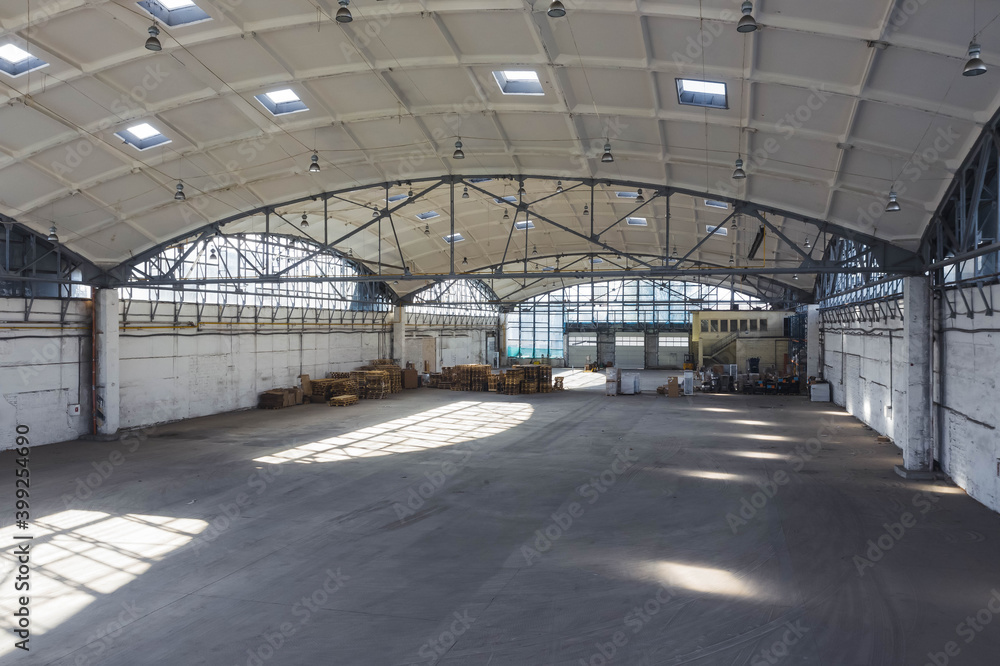 Huge industrial warehouse. Modern interior. Unique architecture. Hemispherical reinforced concrete load bearing roof. Stack wooden pallets. Huge industrial warehouse. Modern interior. Unique architecture. Hemispherical reinforced concrete load bearing roof. Stack wooden pallets.