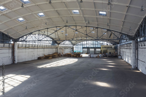 Huge industrial warehouse. Modern interior. Unique architecture. Hemispherical reinforced concrete load bearing roof. Stack wooden pallets.