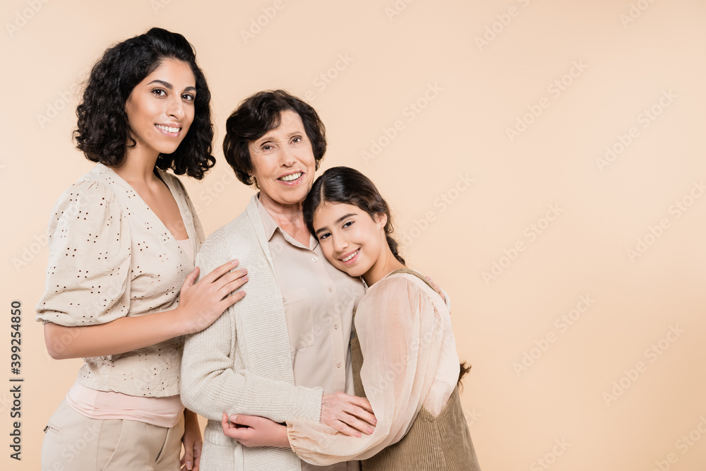 Hispanic women and kid smiling while embracing each other isolated on beige, three generations of women Hispanic women and kid smiling while embracing each other isolated on beige, three generations of women